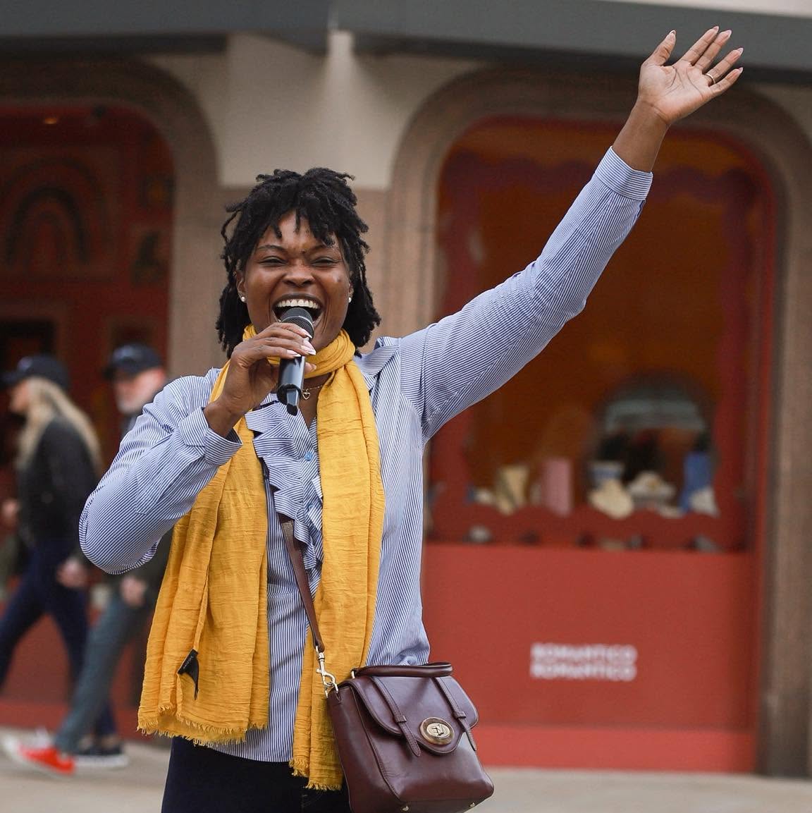 A woman joyfully singing during an outdoor LCC gathering